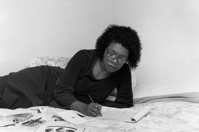 Africanwoman writing on her bed