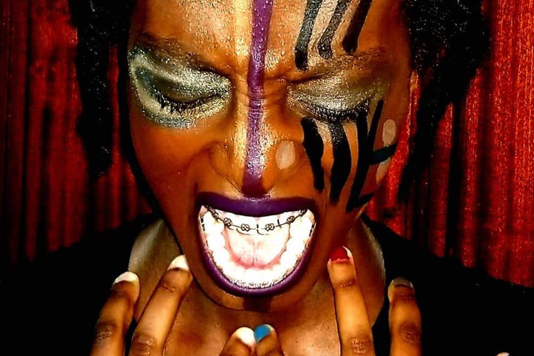 An African woman screaming with facial paintings on her face