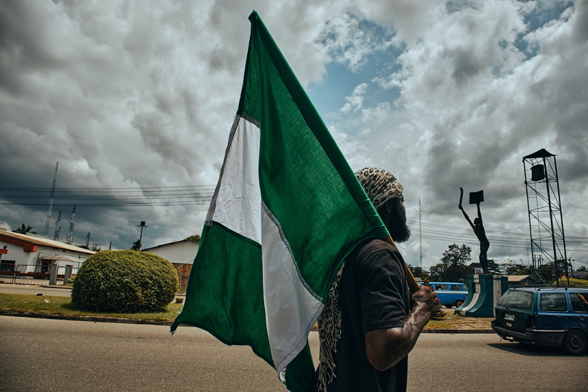 An African man holding a nigerian flag.