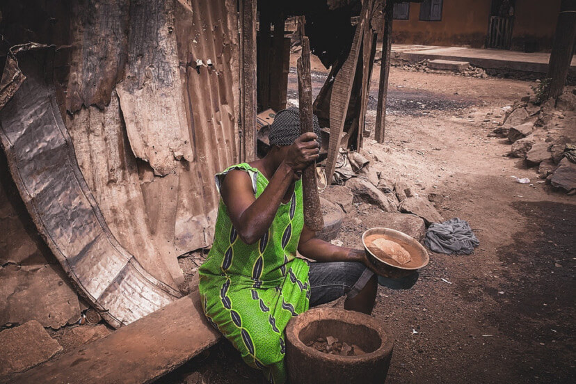 African woman pounding food.