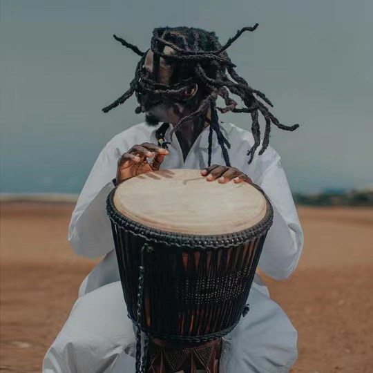 African man with dreadlocks drumming
