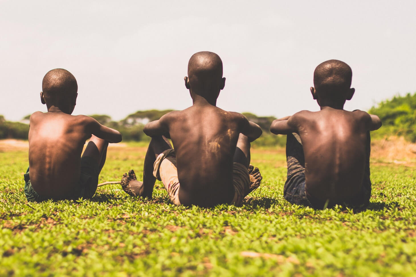 Three young african boys sitted next to each other.