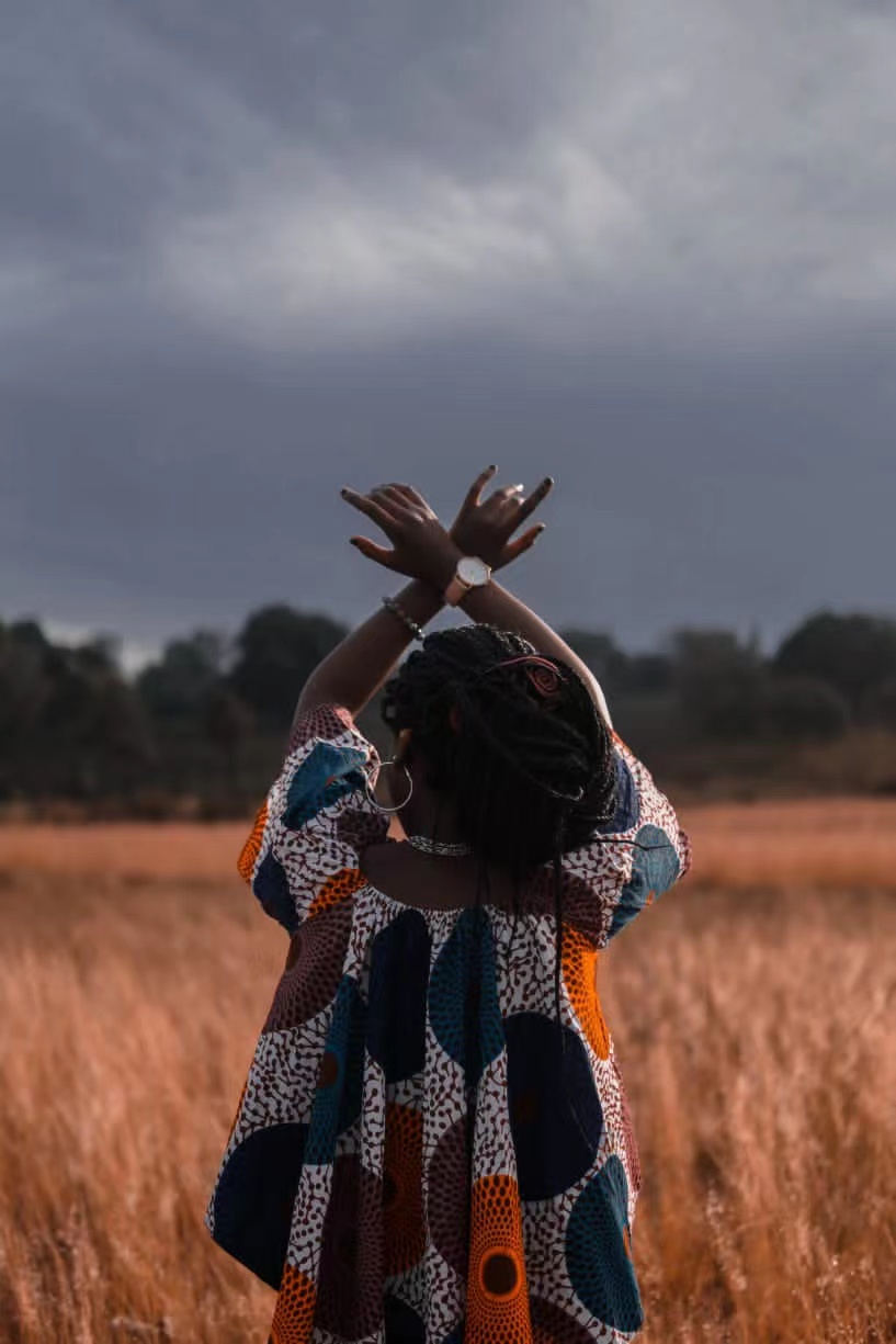 African woman with hands in the air.