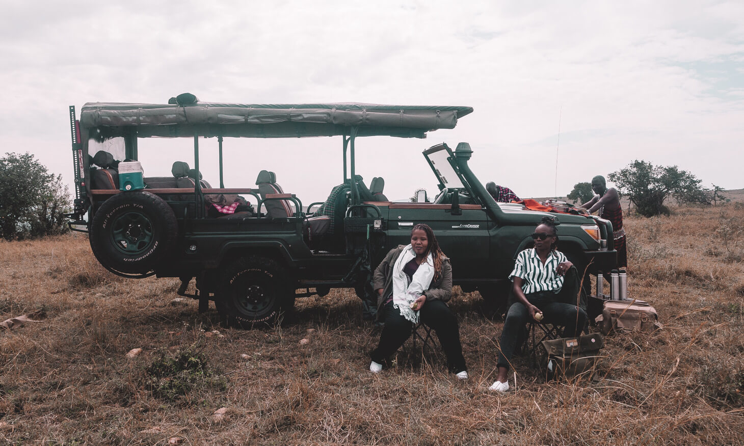 People sitted beside a land cruiser in the safari