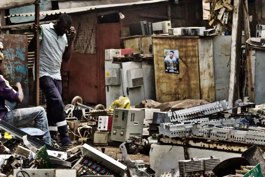 African man walking on spare parts.